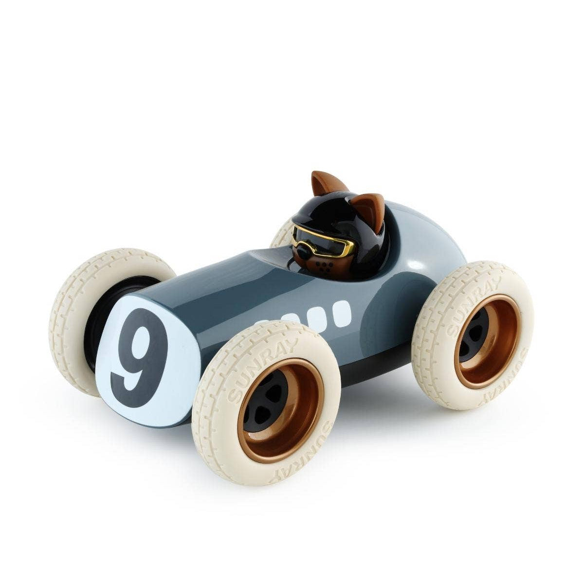 A stylized toy race car with a dark gray body, cream-colored tires, a white front number plate with the number 9, and a small black cat driver wearing gold goggles, shown on a plain white background.