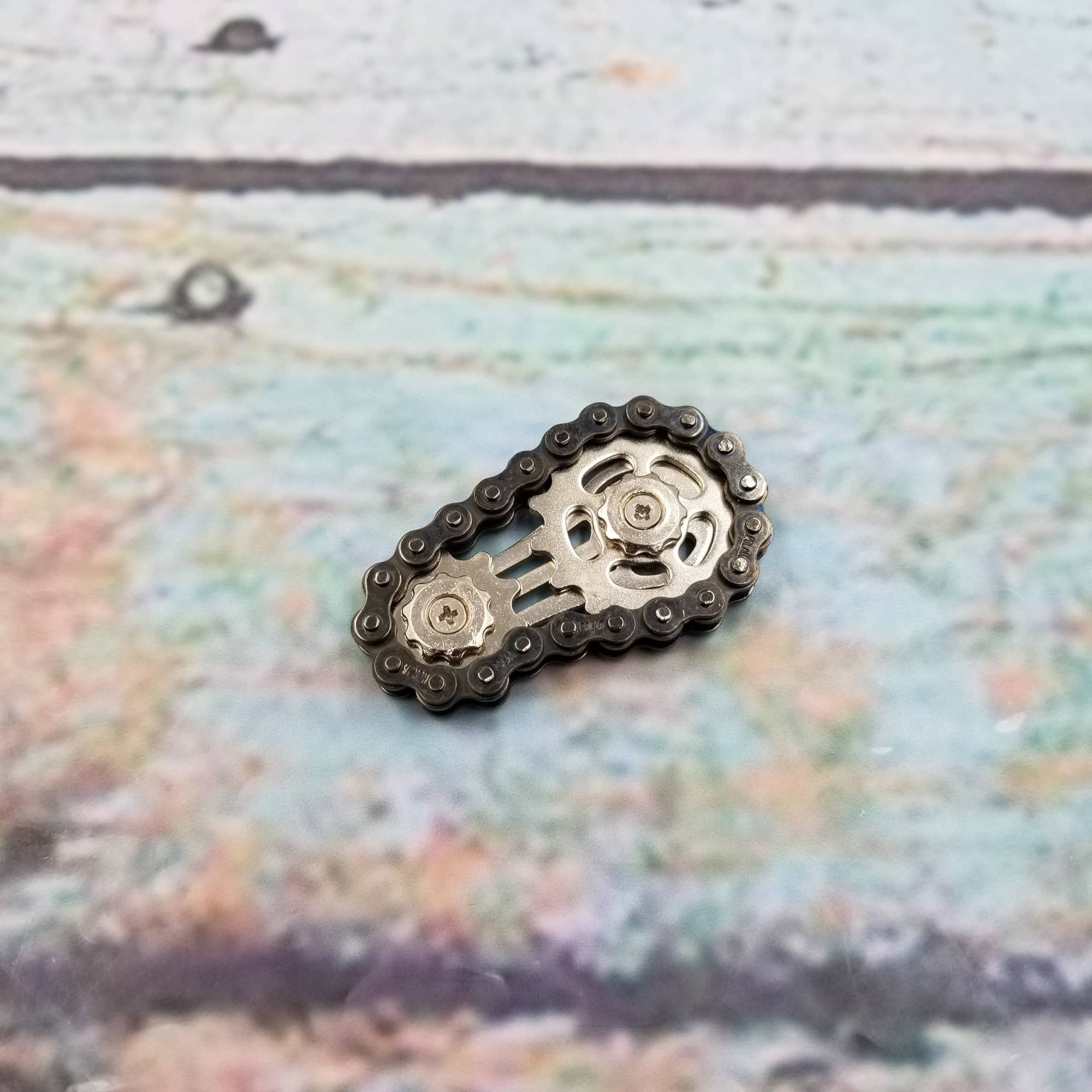 Metallic chain and sprocket on a textured fabric background