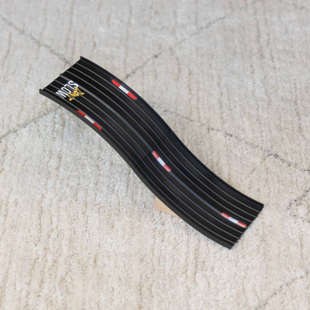 Black plastic strip with red and white accents on a beige carpet