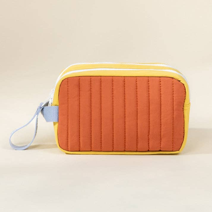 Quilted rectangular pouch with yellow top and orange body on a beige background
