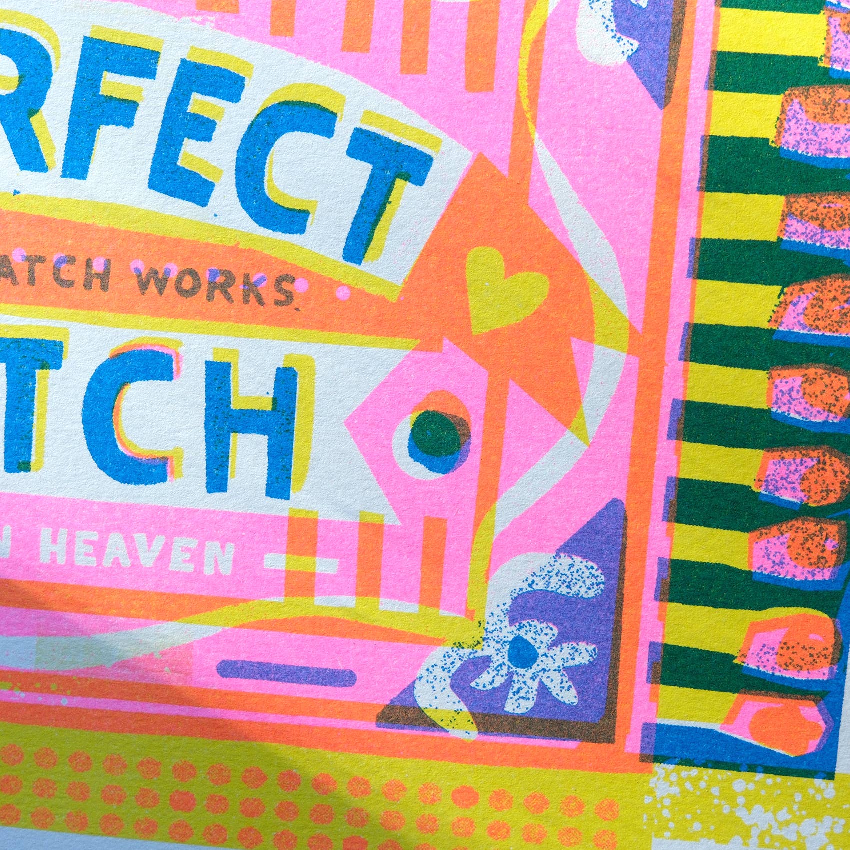 A close-up of a colorful graphic print featuring the word 'PERFECT' in large blue letters with yellow and white outlines, alongside pink, orange, green, and blue abstract shapes and patterns.