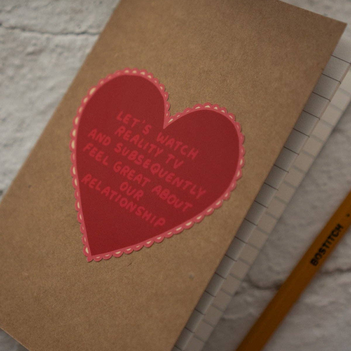 Notebook with a red heart-shaped patch on a textured surface