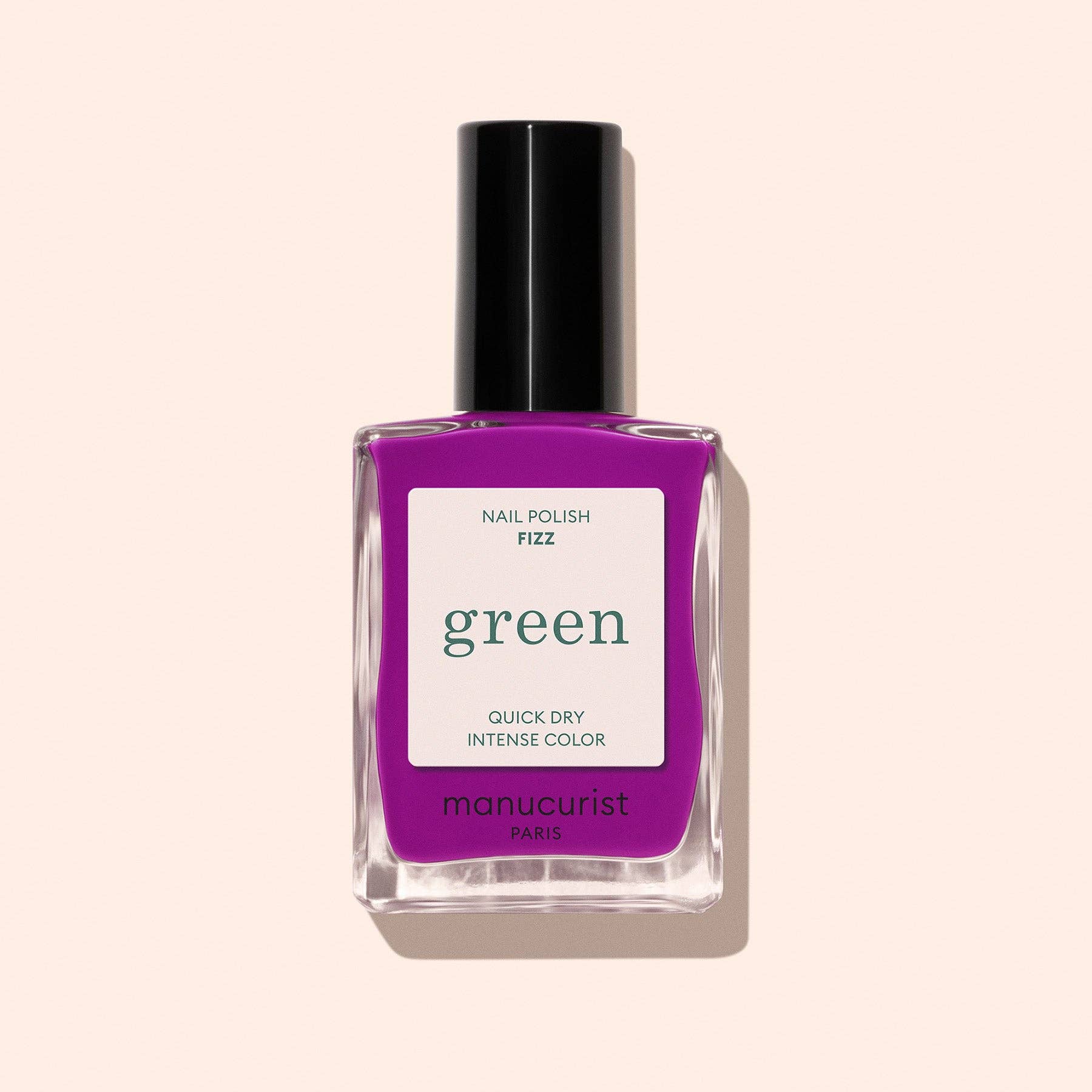 Purple nail polish bottle with 'manucurist' label on a beige background