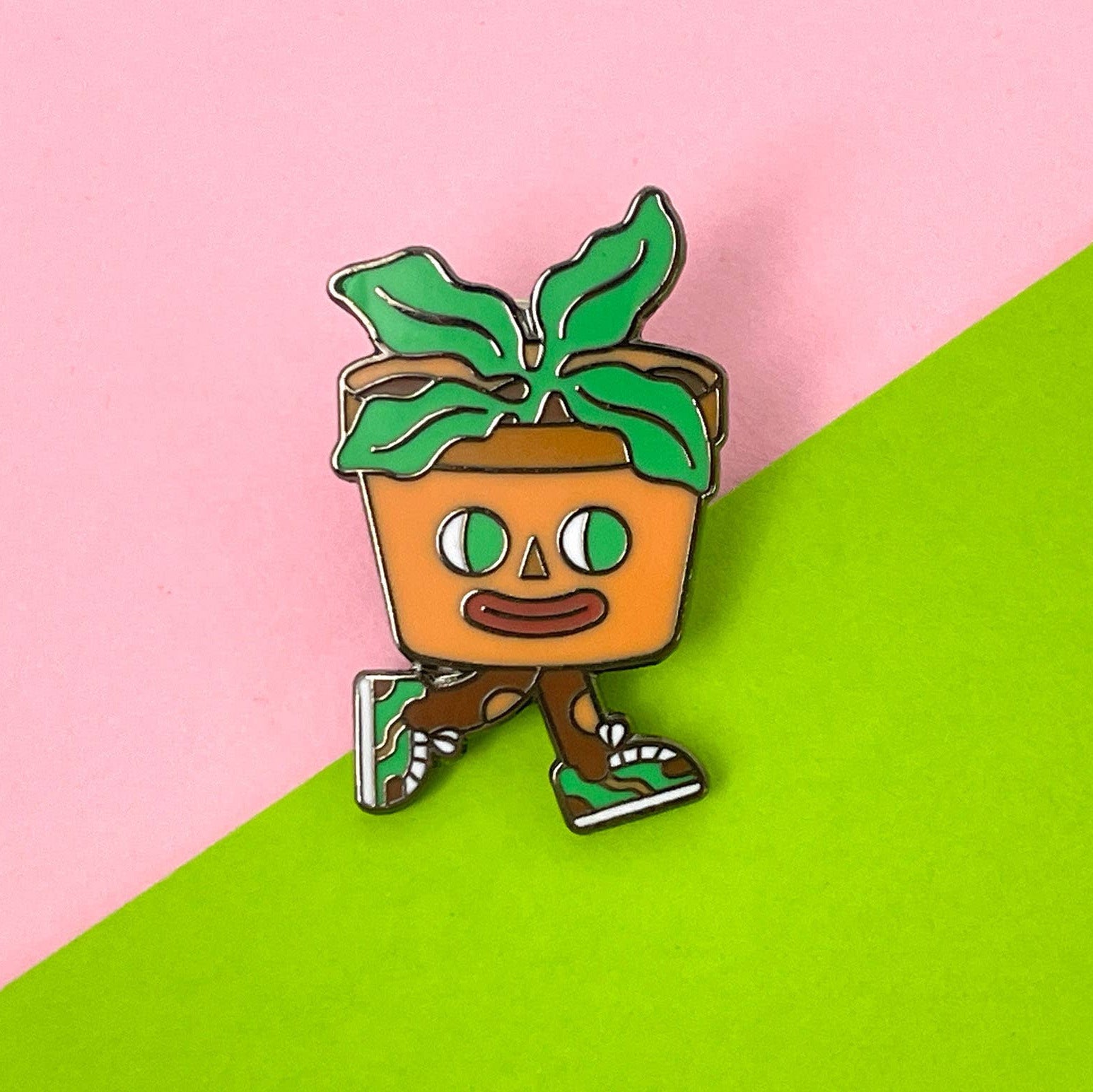 Cartoon plant character with a pot on a pink and green background