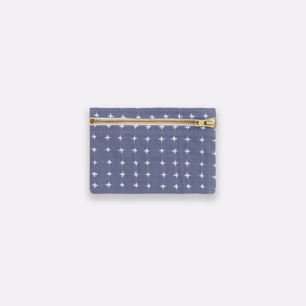 Small pouch with star pattern and gold zipper on a light gray background