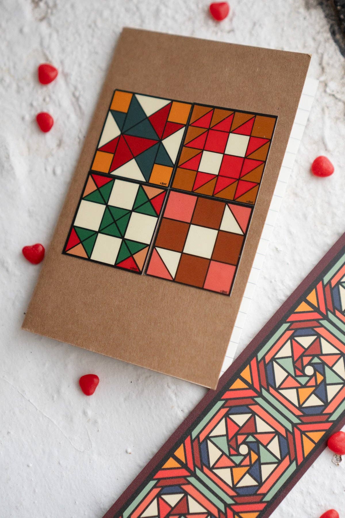 Geometric patterned card and bookmark on a textured surface with heart-shaped objects.