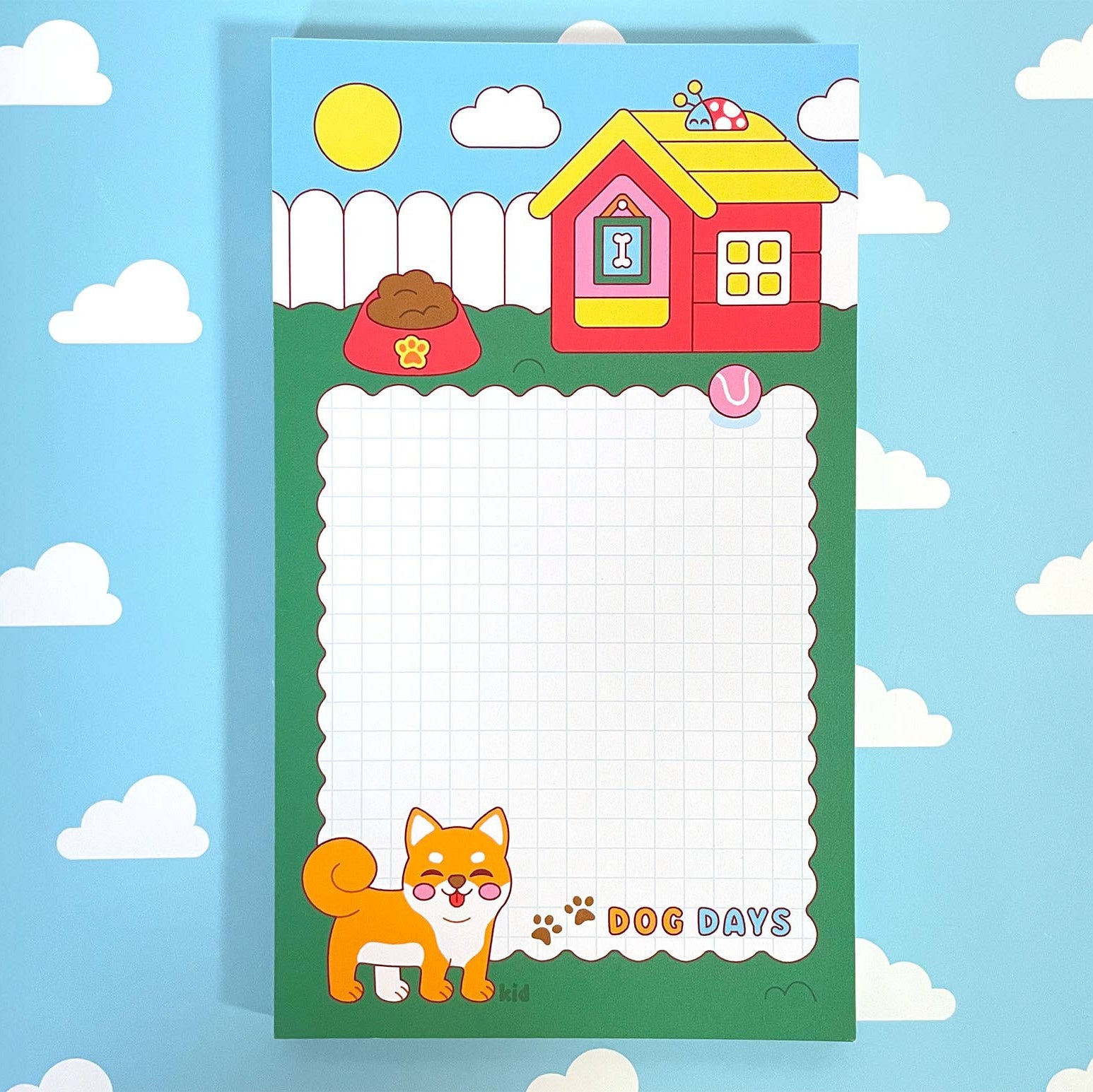 Notepad with a cartoon dog and house design on a blue background with clouds