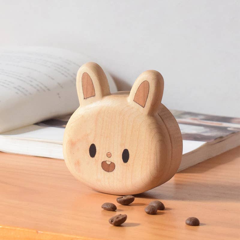 Wooden rabbit-shaped container with coffee grounds on a wooden surface