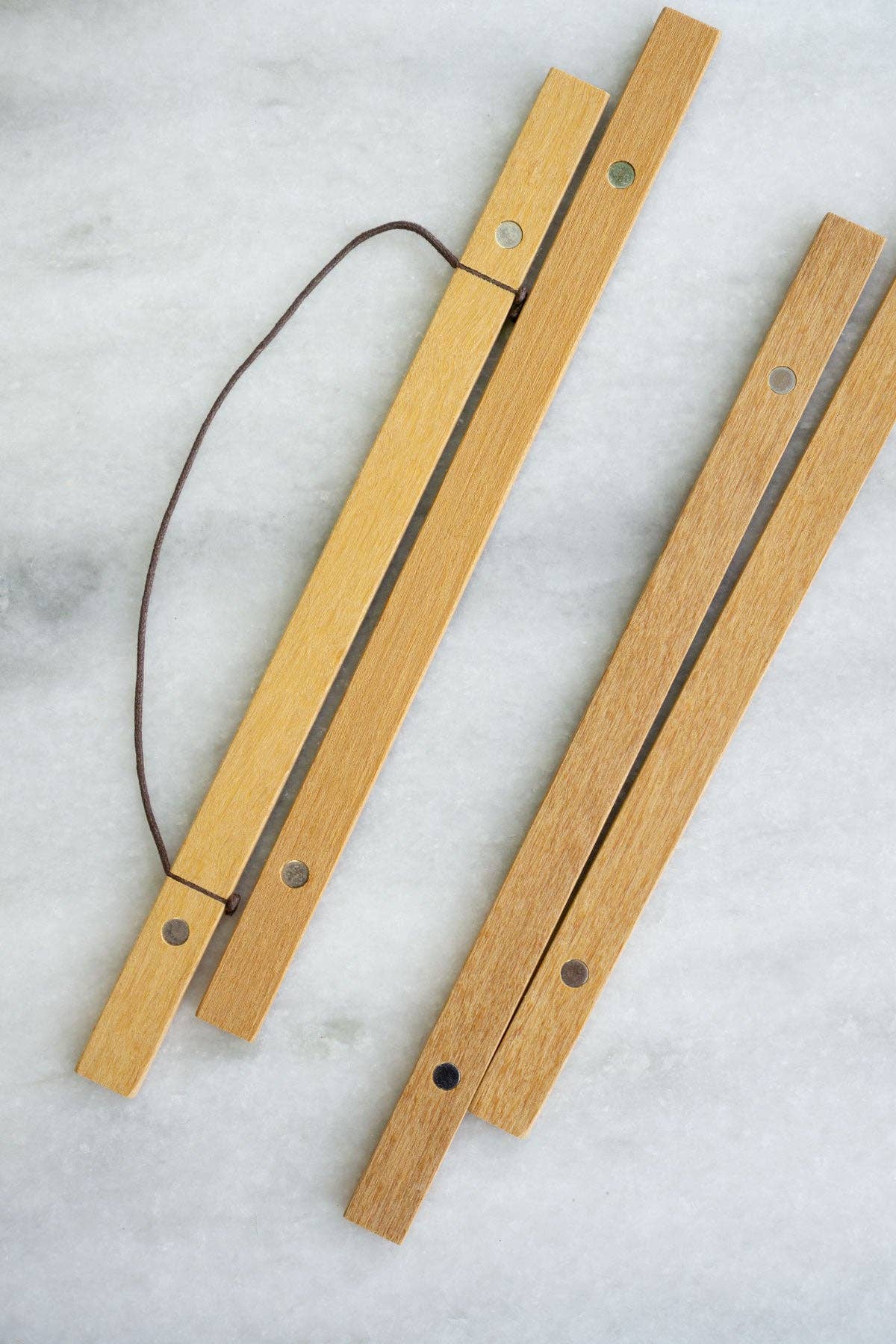 Two wooden sticks with metal loops on a light gray background