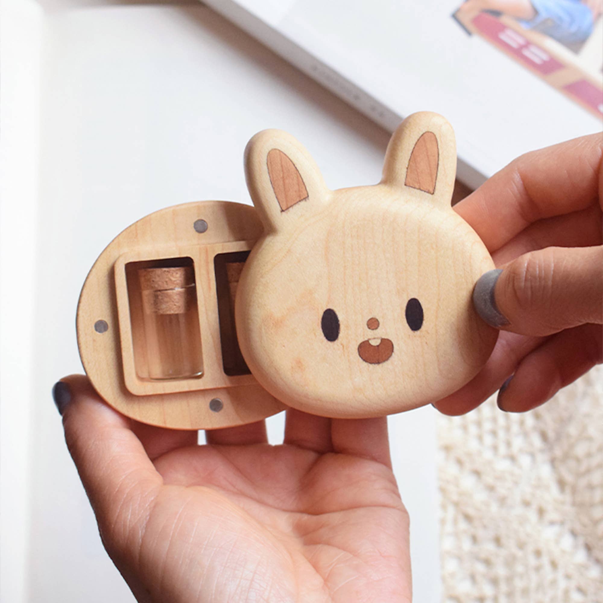 Wooden rabbit-shaped container held in a hand with a blurred background