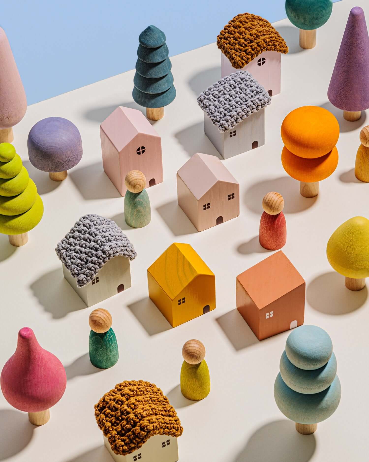 Colorful toy houses and trees on a light surface with a blue background