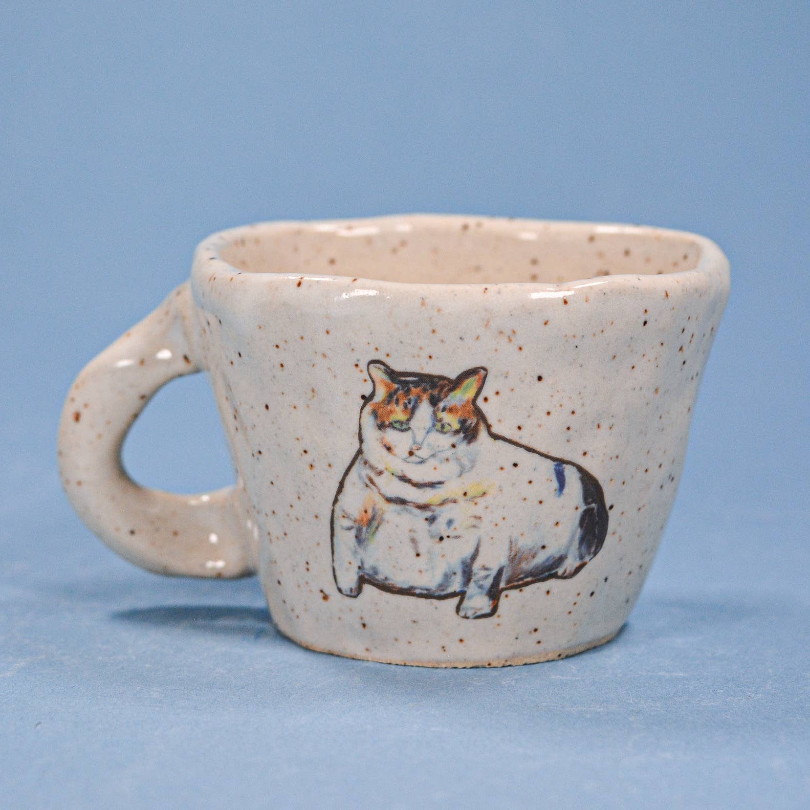 Ceramic mug with a cat illustration on a blue background