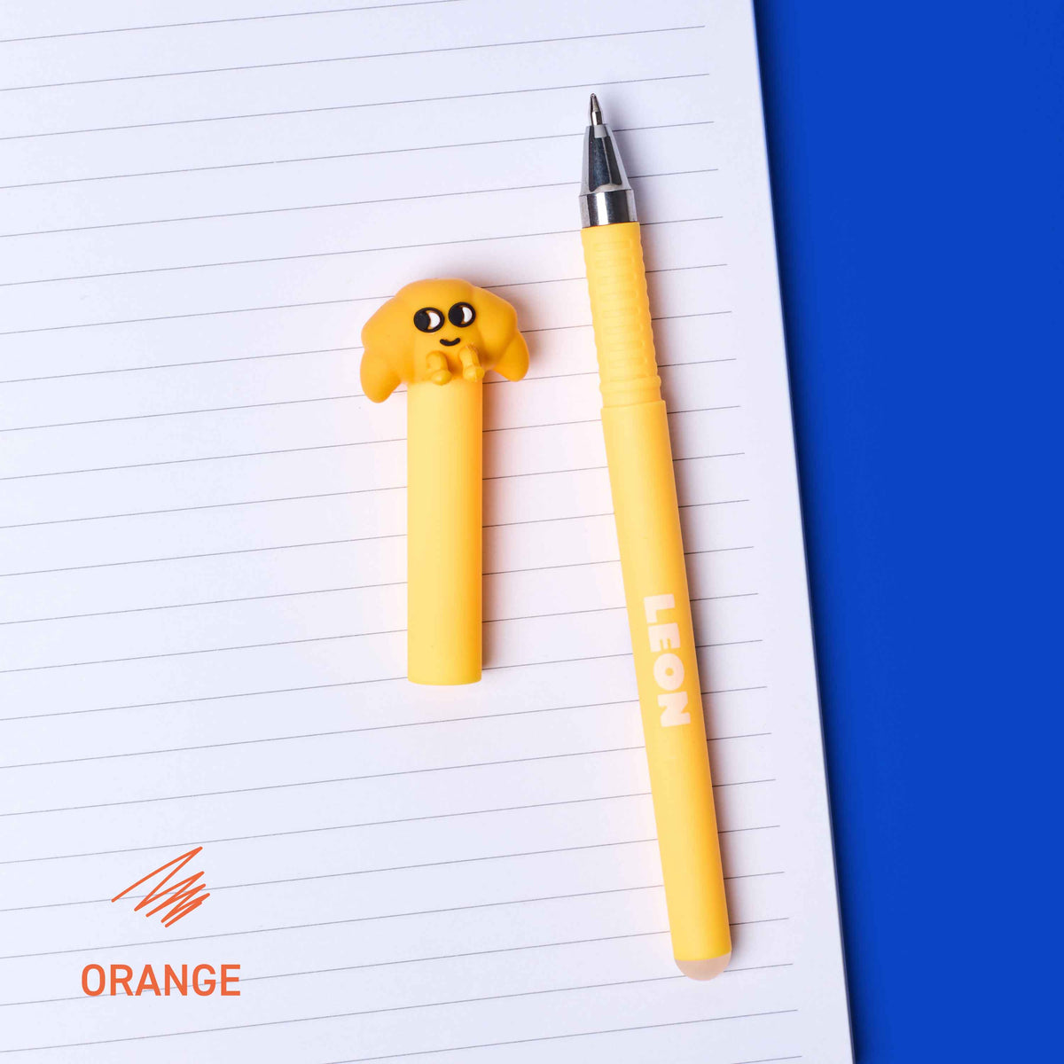 Yellow pen with cartoon character on top of lined paper against a blue background