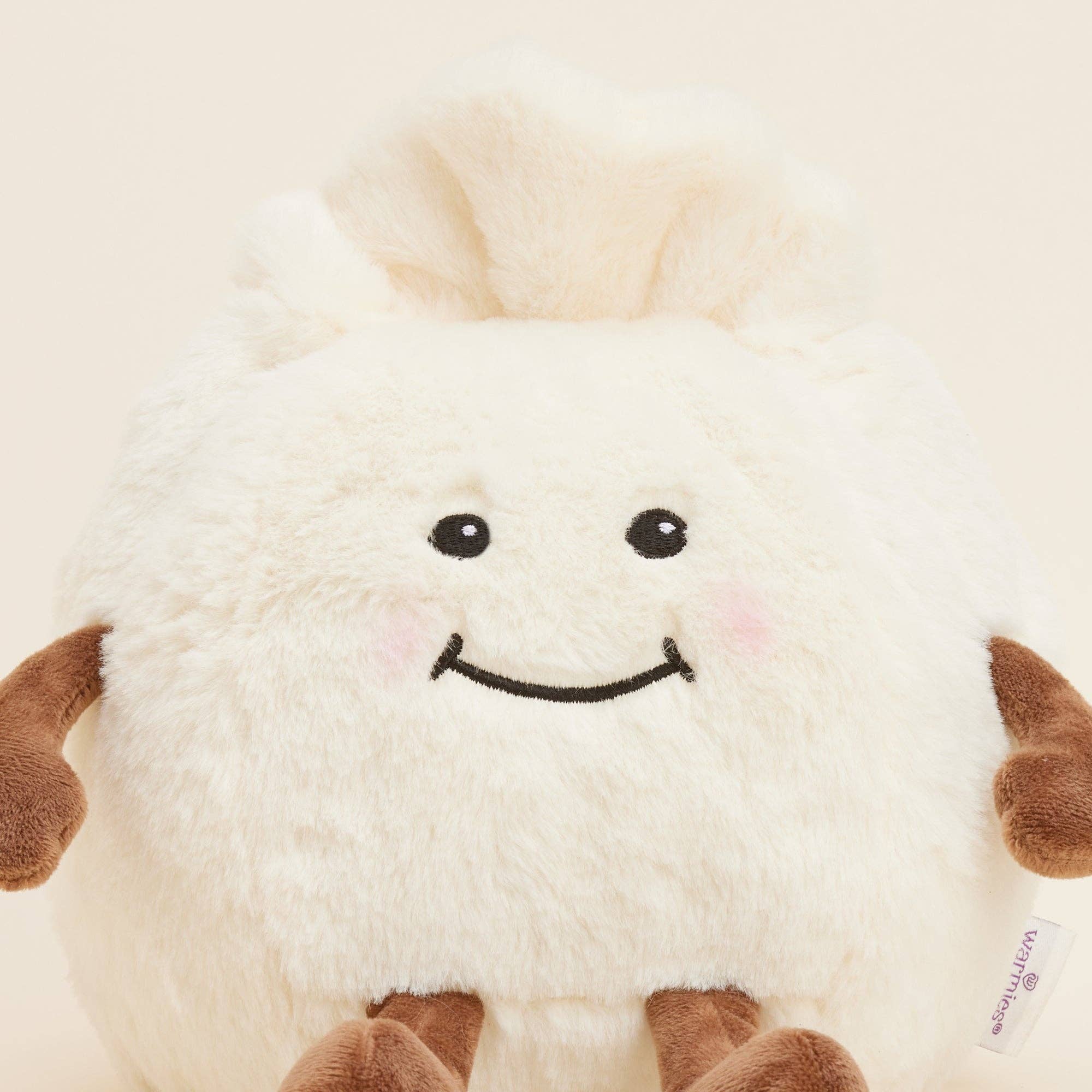 Plush dumpling with a smiling face on a beige background