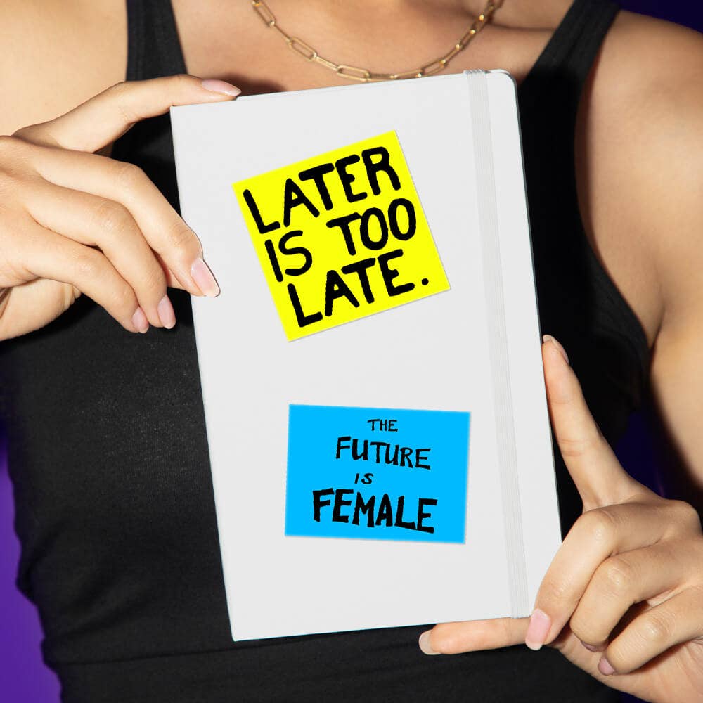 Person holding a notebook with motivational stickers on a dark background