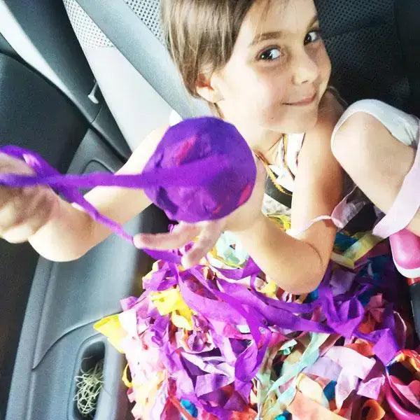 Child playing with colorful surprise ball inside a vehicle