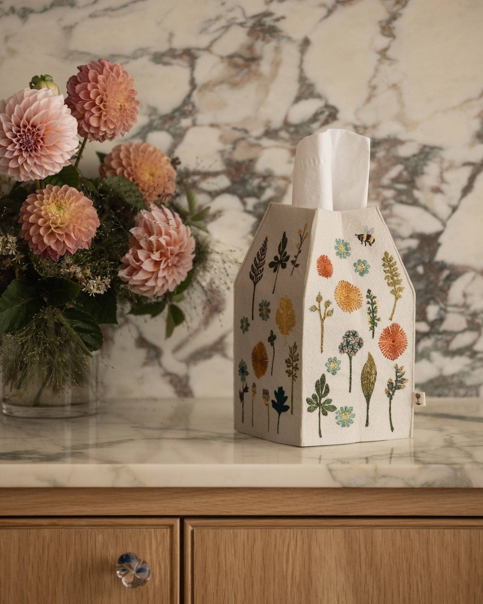 Decorative tissue box with floral design on a marble surface
