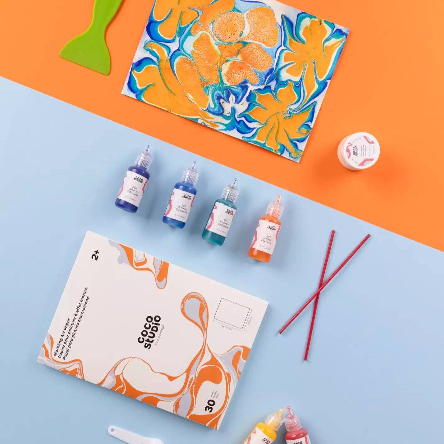 Color mixing set with bottles, a palette, and tools on a blue and orange background