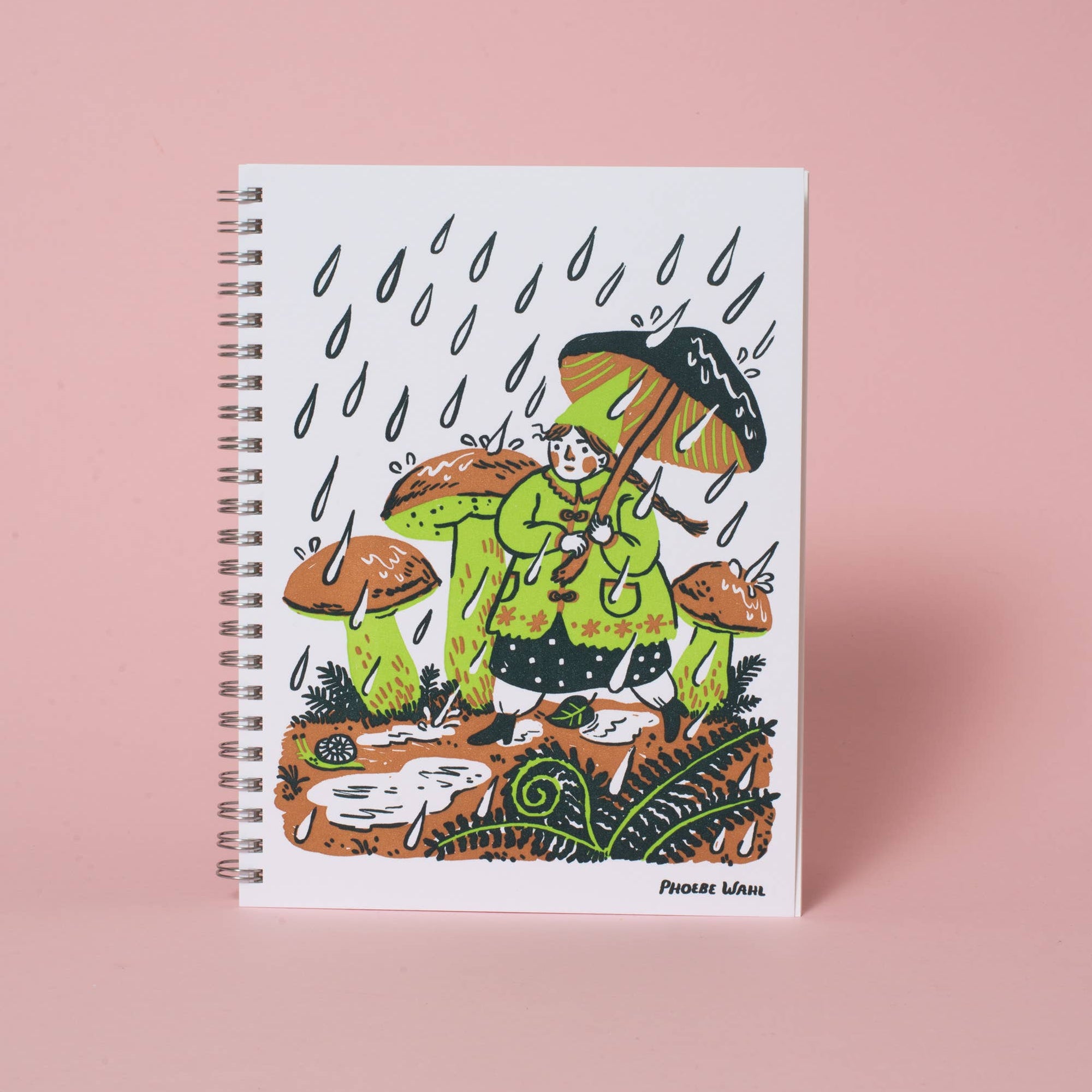 Notebook with a colorful illustration of a person in a raincoat and boots standing in water, surrounded by mushrooms on a pink background.