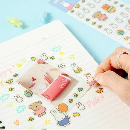 Hand arranging colorful stickers on a notebook with a blue background