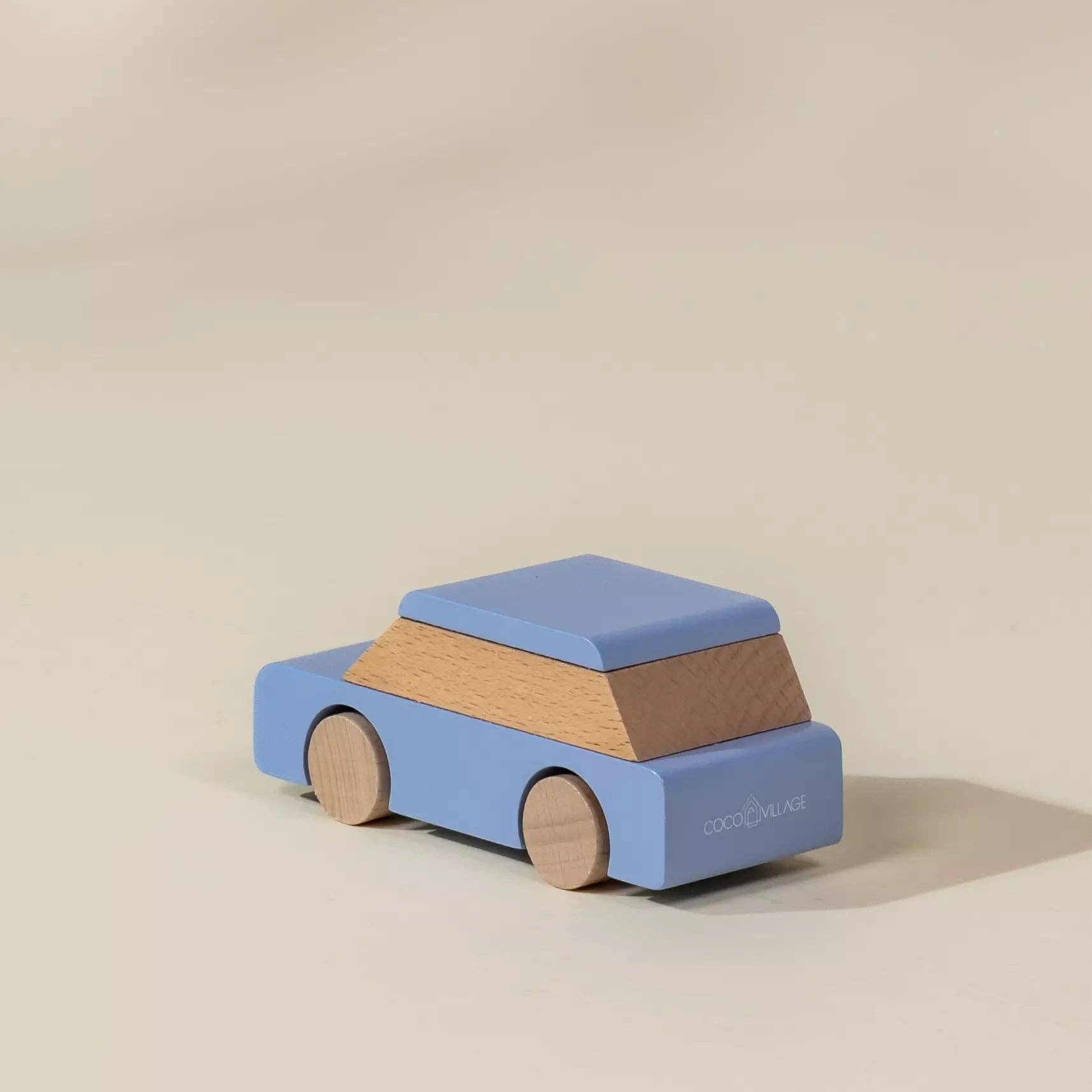 Wooden toy car with blue top and brown body on a beige background