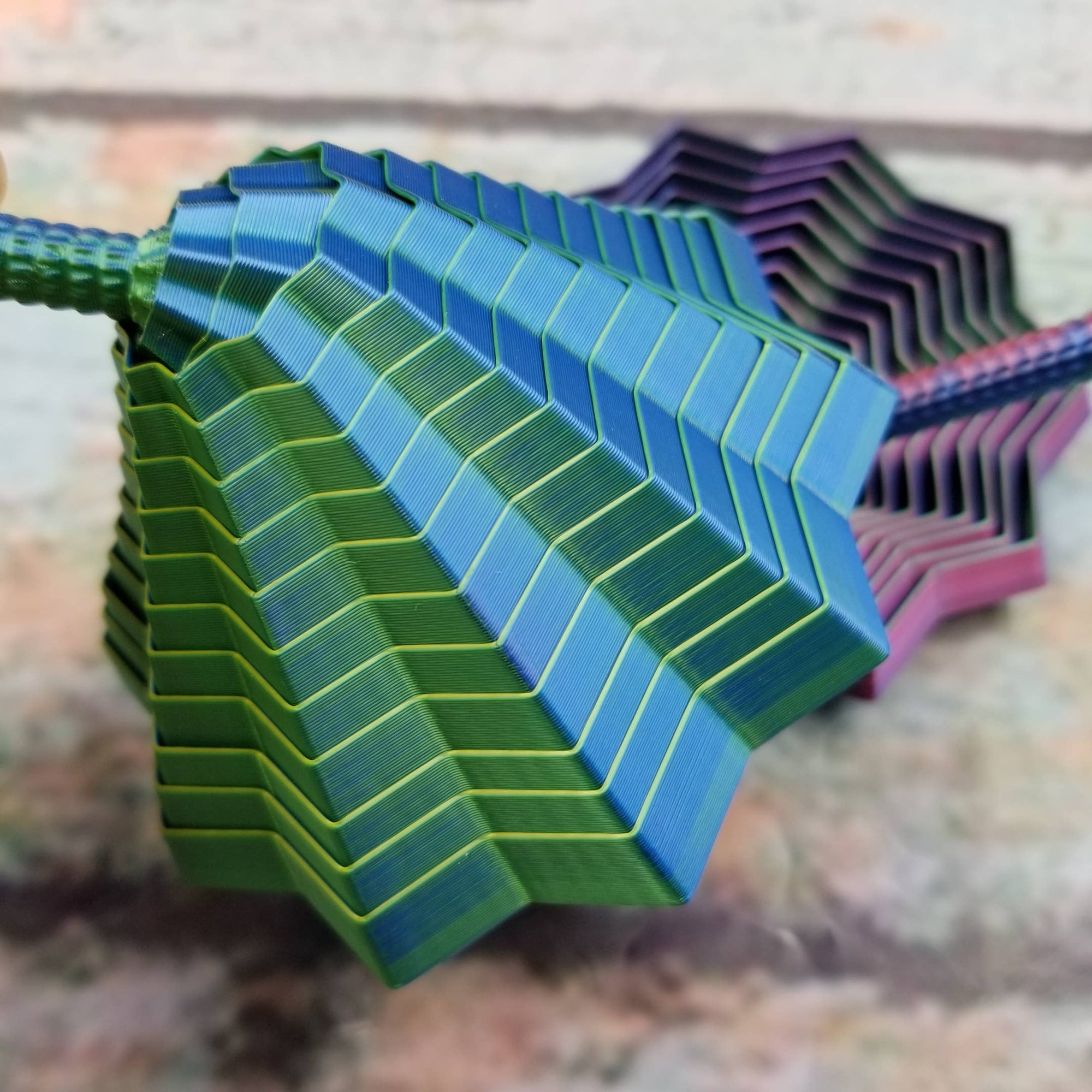 Stack of colorful plastic straws with a geometric pattern on a textured surface.