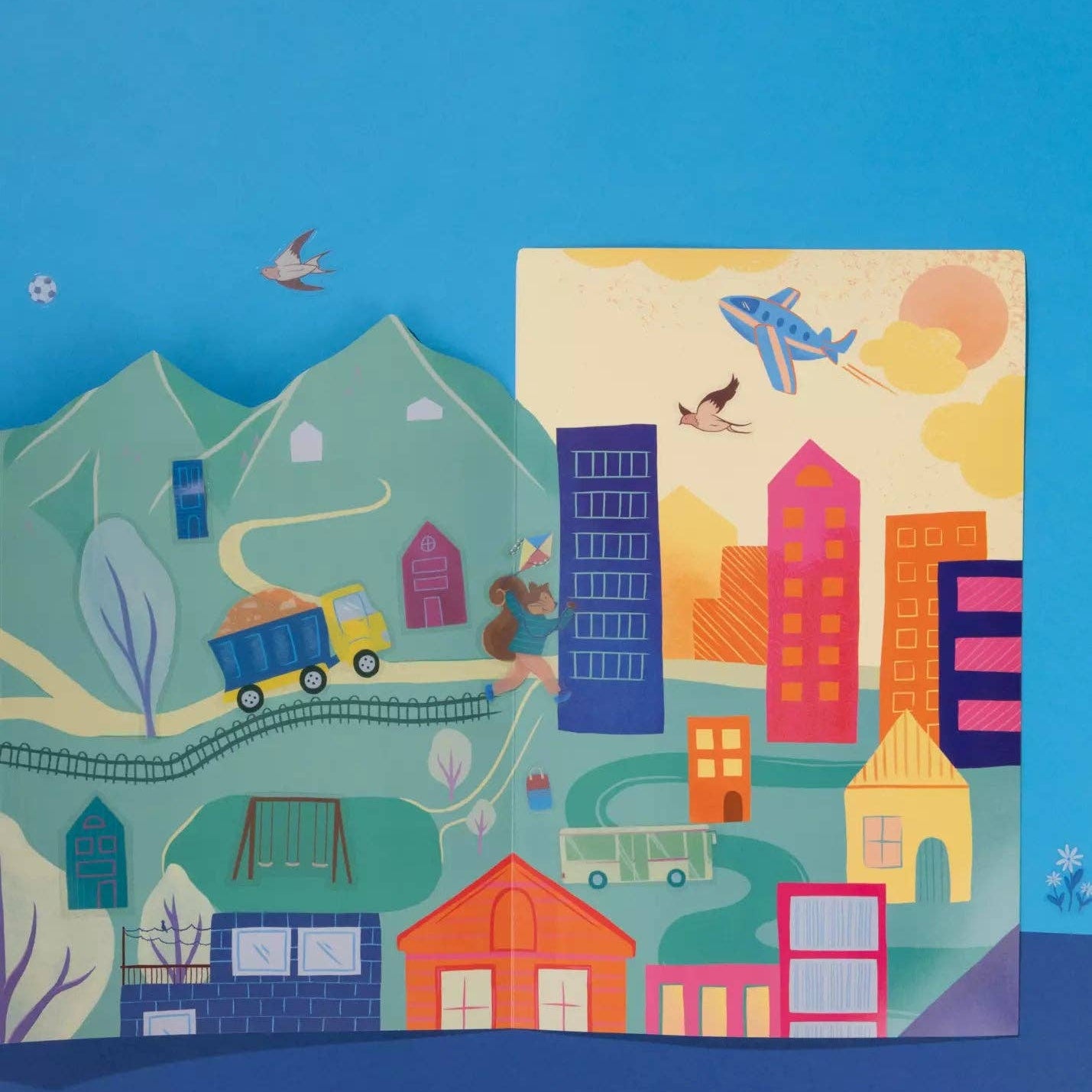 Colorful children's wall mural with buildings, animals, and vehicles on a blue background