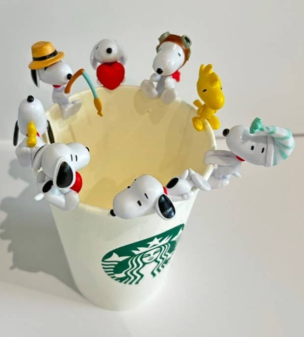 Starbucks cup with Snoopy figurines on a white background
