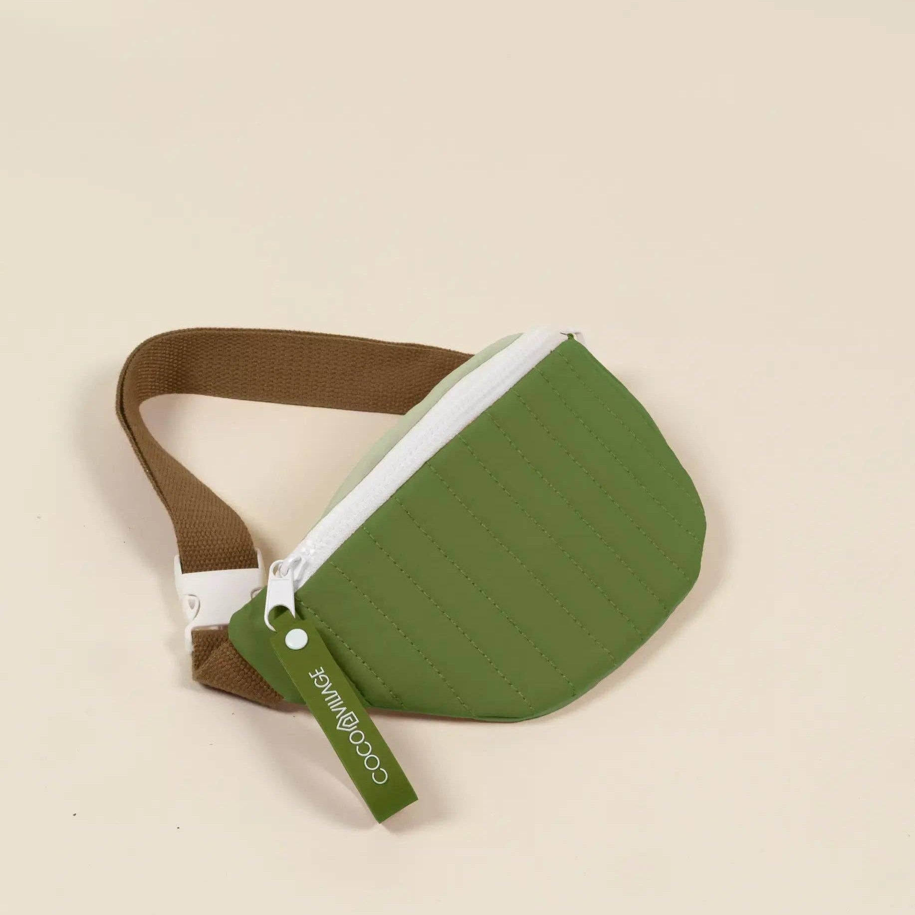 Green and brown waist bag on a beige background