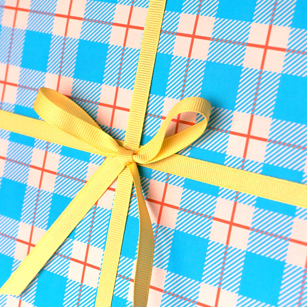 Gift with yellow ribbon on blue plaid paper