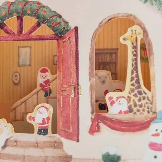 Decorative paper cutout of a Christmas scene with Santa Claus, a snowman, and a giraffe.