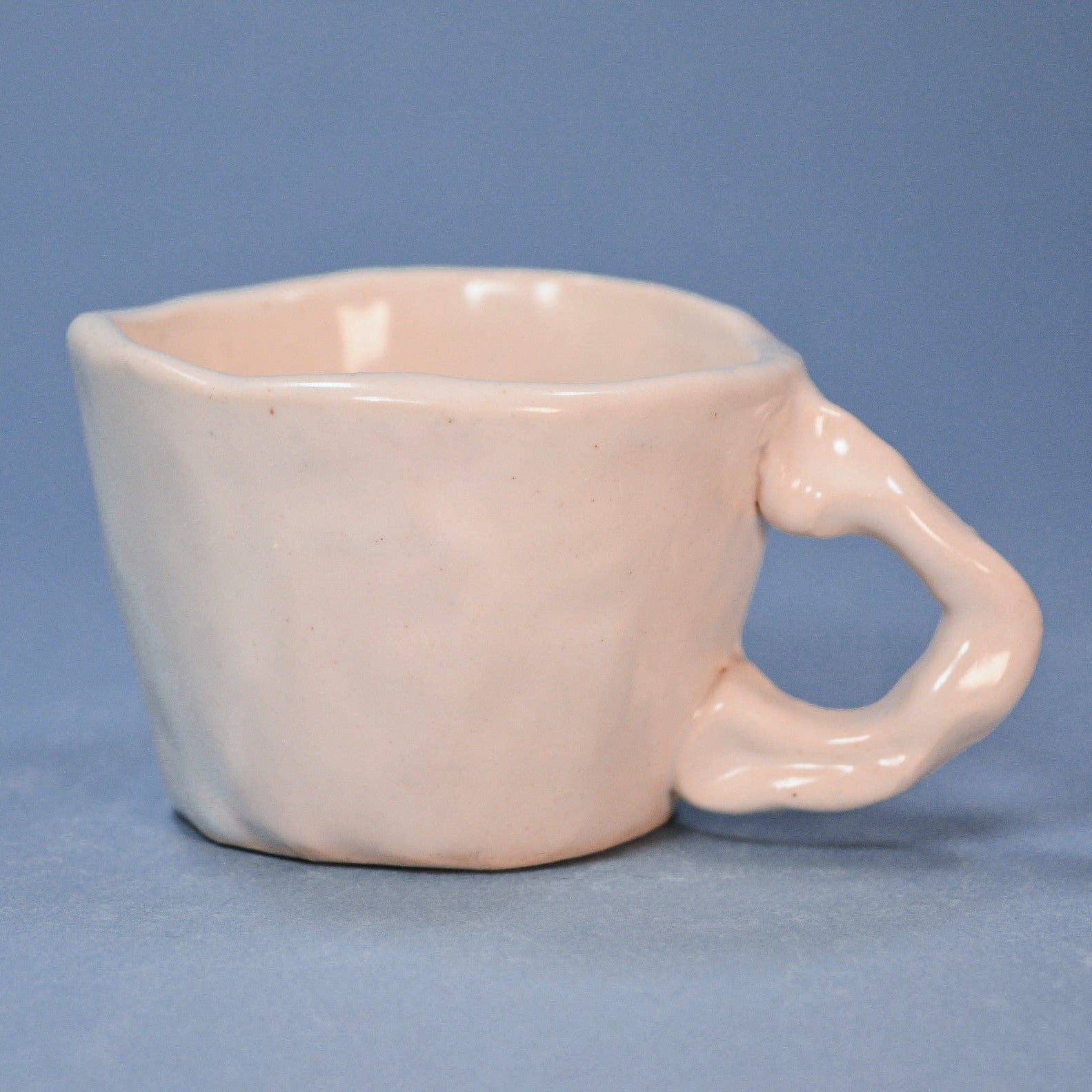 White ceramic cup with handle on a blue background