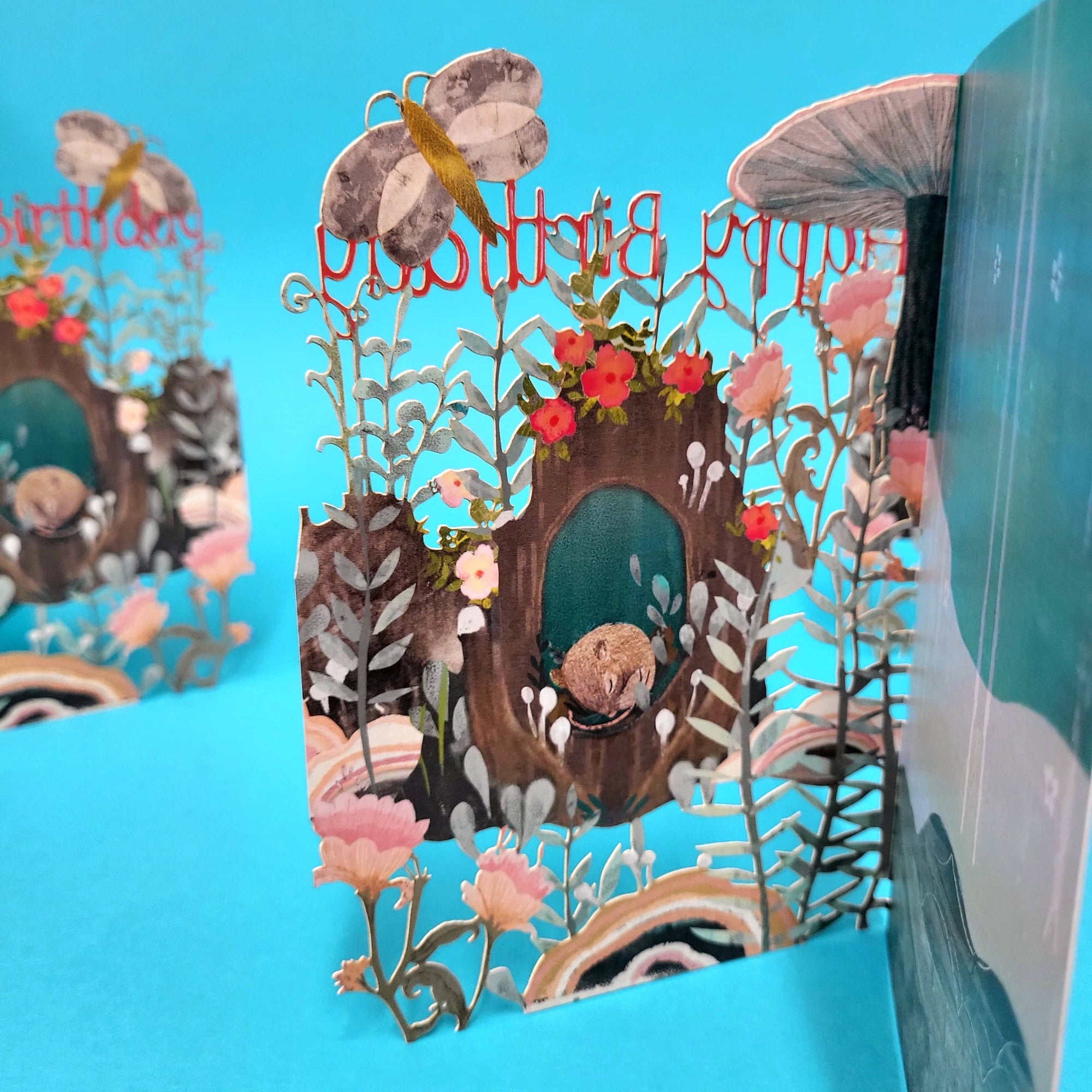Pop-up birthday card with animals and flowers on a blue background
