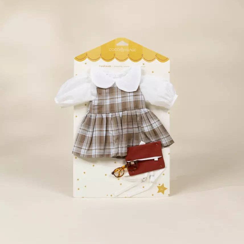 Packaged doll outfit with a plaid dress and white blouse on a beige background