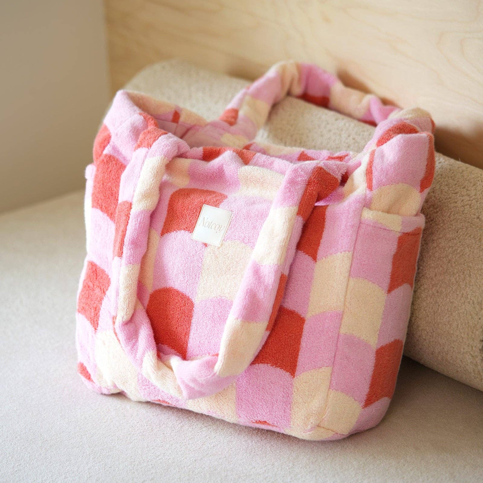 Pink and white checkered bag on a light-colored surface