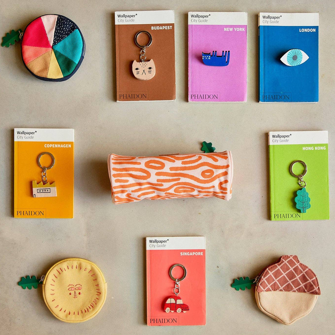 Collection of colorful keychains and pouches on a beige background