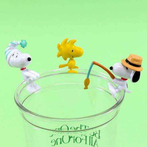 Three cartoon dog figurines on a clear glass with a green background