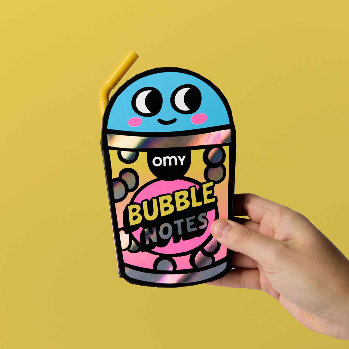 Hand holding a colorful container labeled 'Bubble Notes' against a yellow background