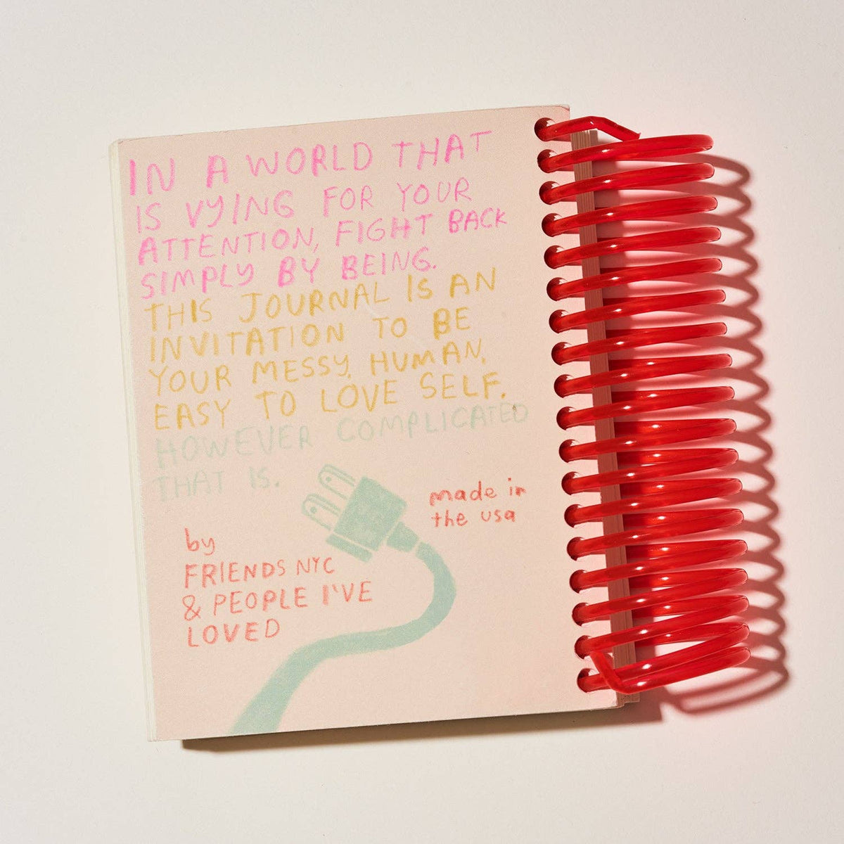 Journal with red spiral binding and motivational text on a white background