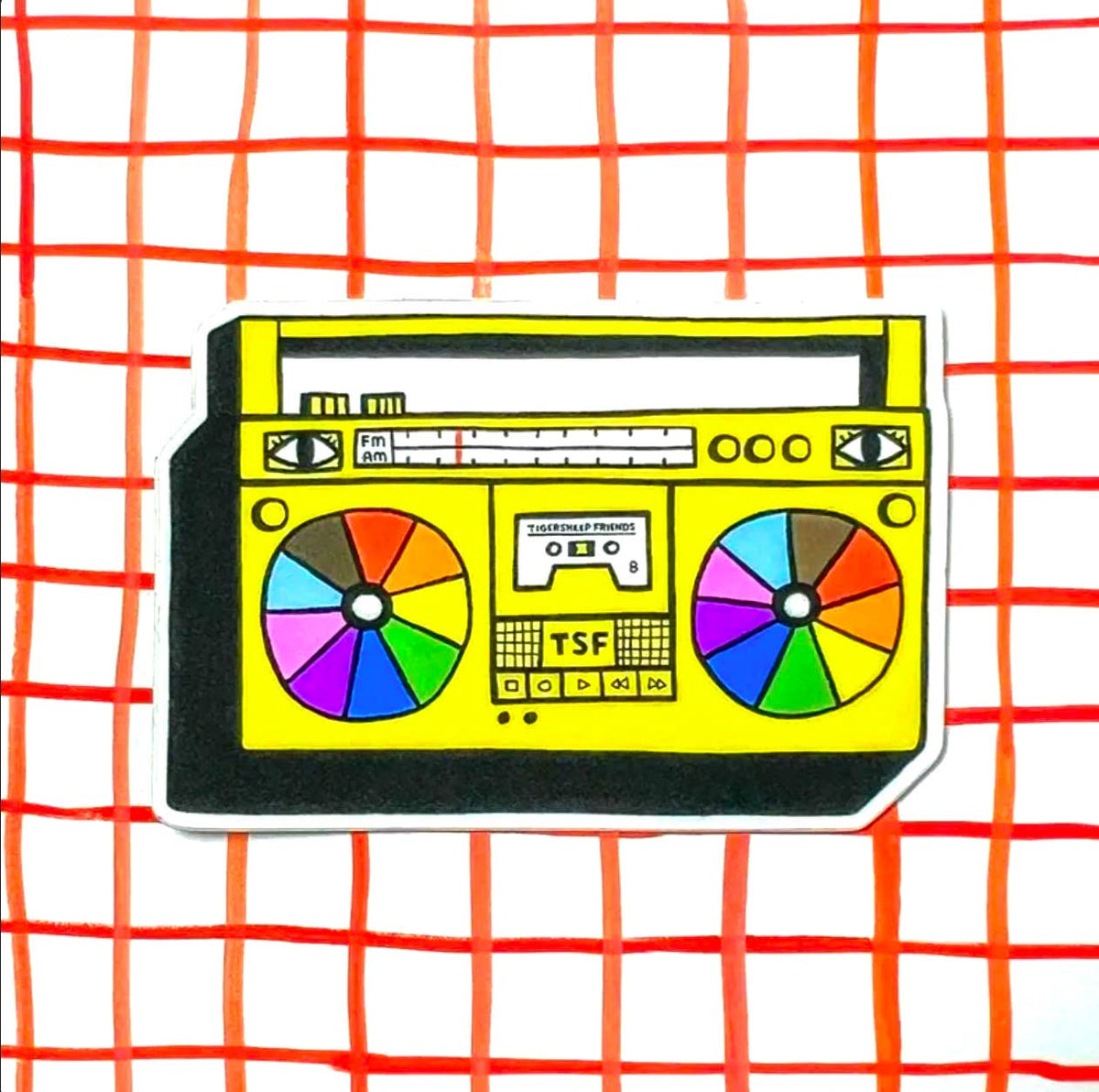 A die-cut sticker featuring a retro-style yellow boombox illustration with multicolored speaker grilles, set against a white background with a red-orange grid pattern.