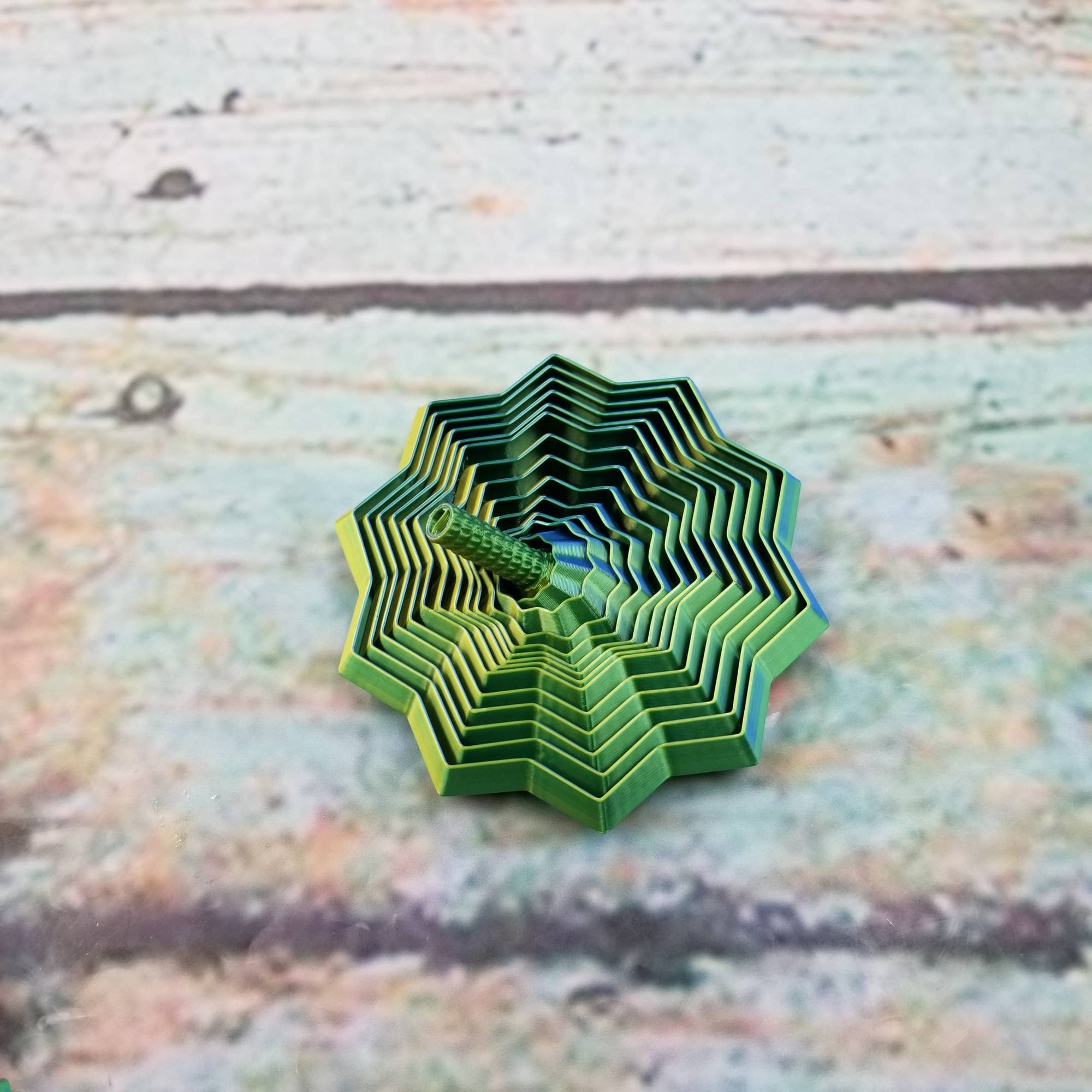 Green geometric paper sculpture on a textured fabric background