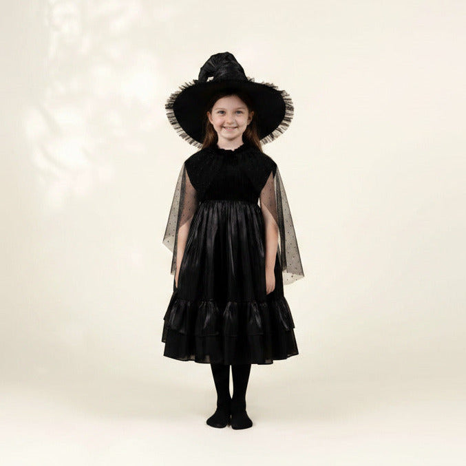 Child wearing a black witch costume with a hat on a white background