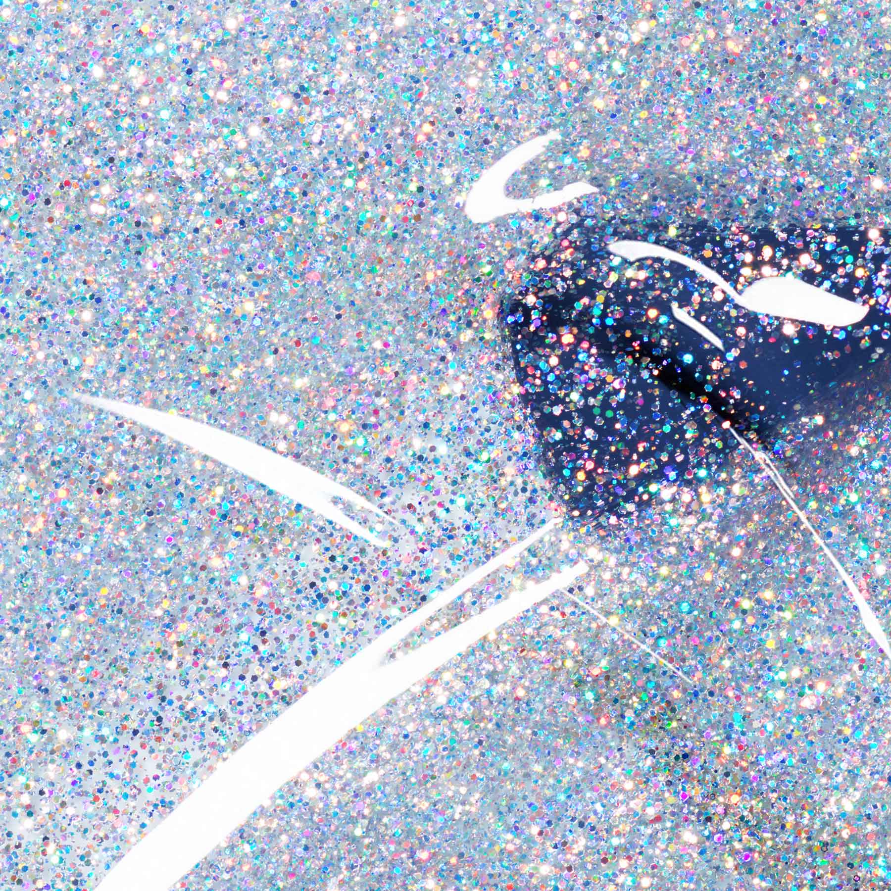 Close-up of a glittery surface with a black object and white lines.