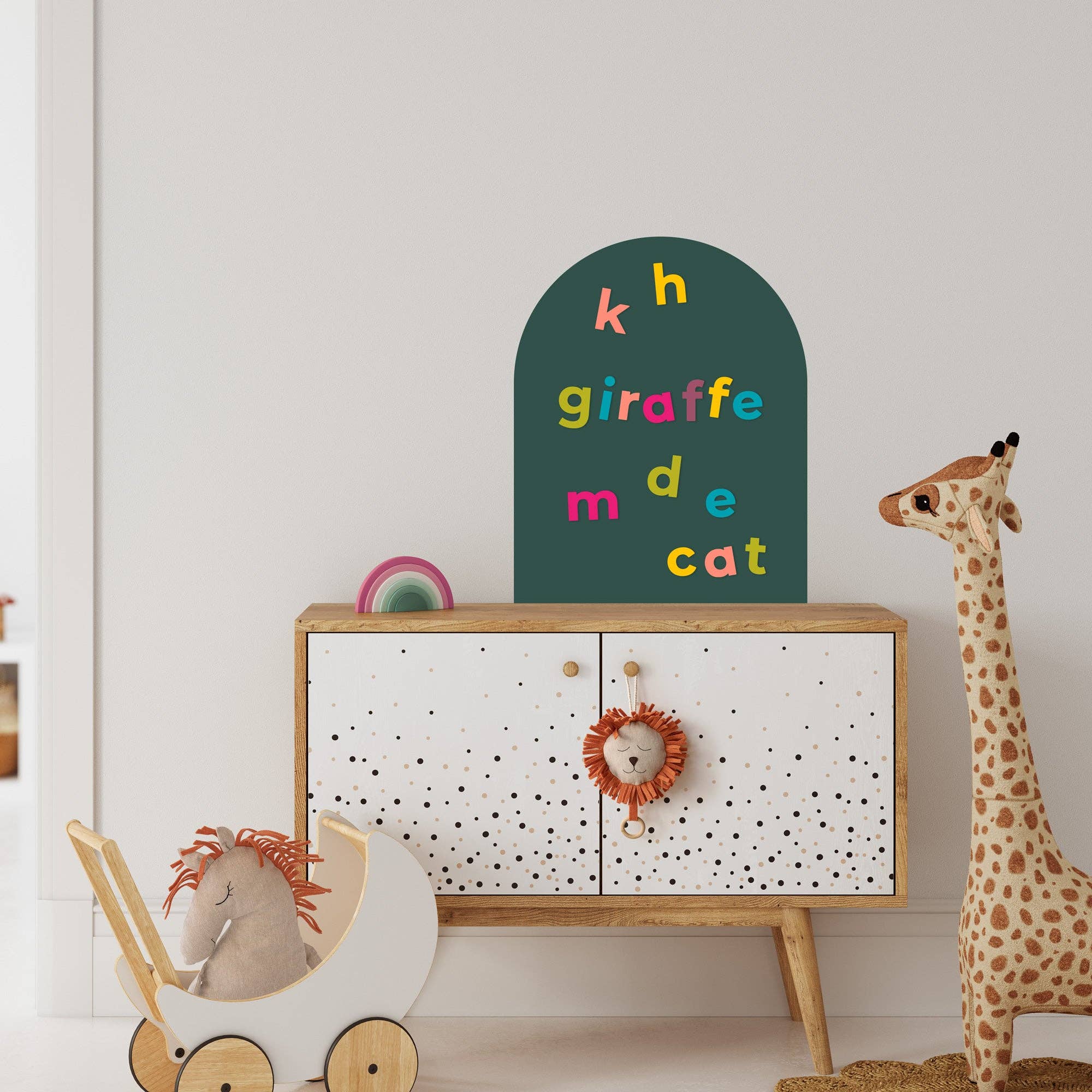 Children's room with a wooden cabinet, toy horse, and giraffe, featuring a colorful alphabet sign.
