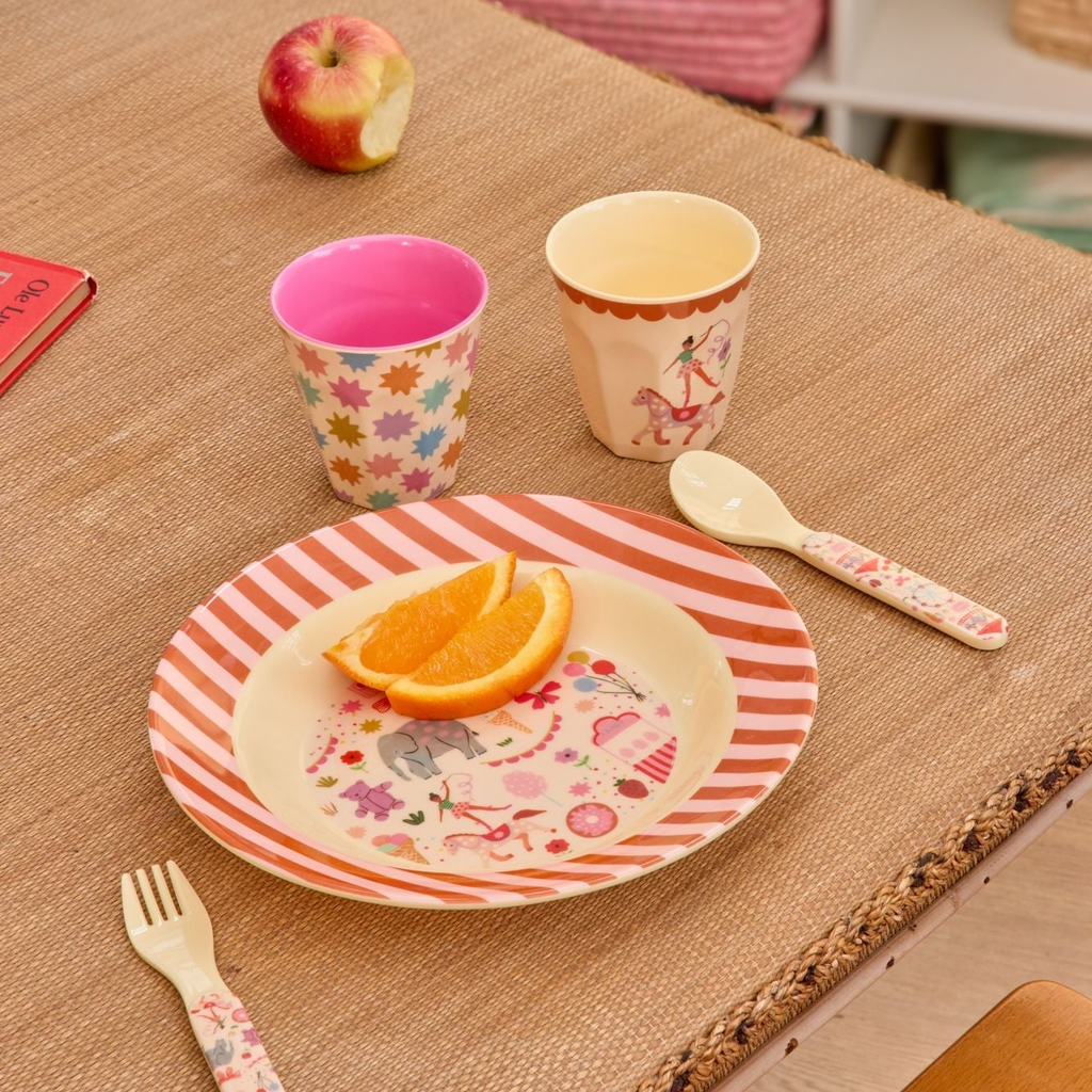 Children's tableware set with cups, plate, fork, and spoon on a textured surface.