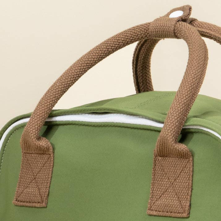 Green bag with brown handles on a beige background