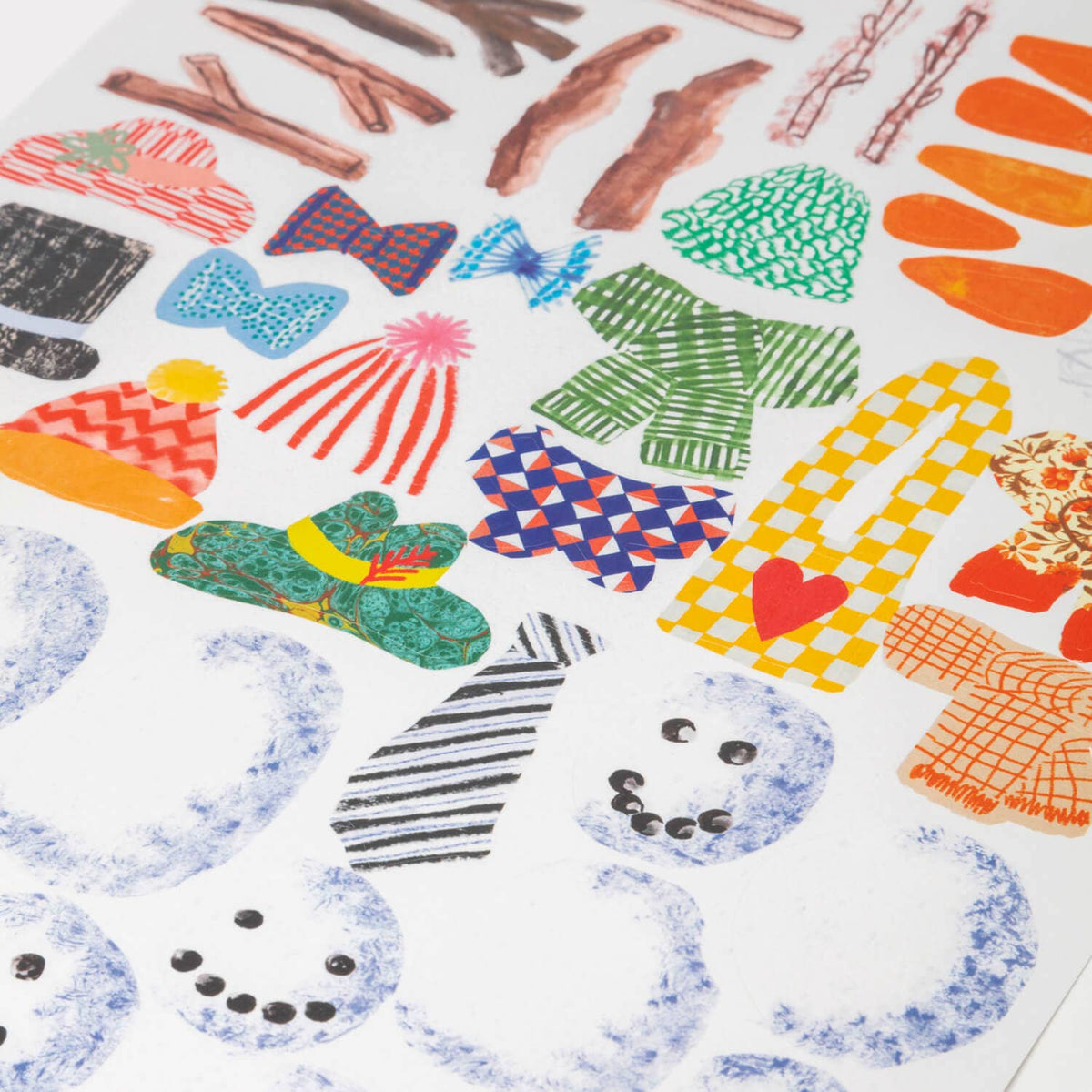 A close-up of a printed sheet filled with colorful winter-themed illustrations and patterns, including striped and checkered hats, scarves, bows, and snowman faces in blue, green, red, orange, yellow, black, and white.