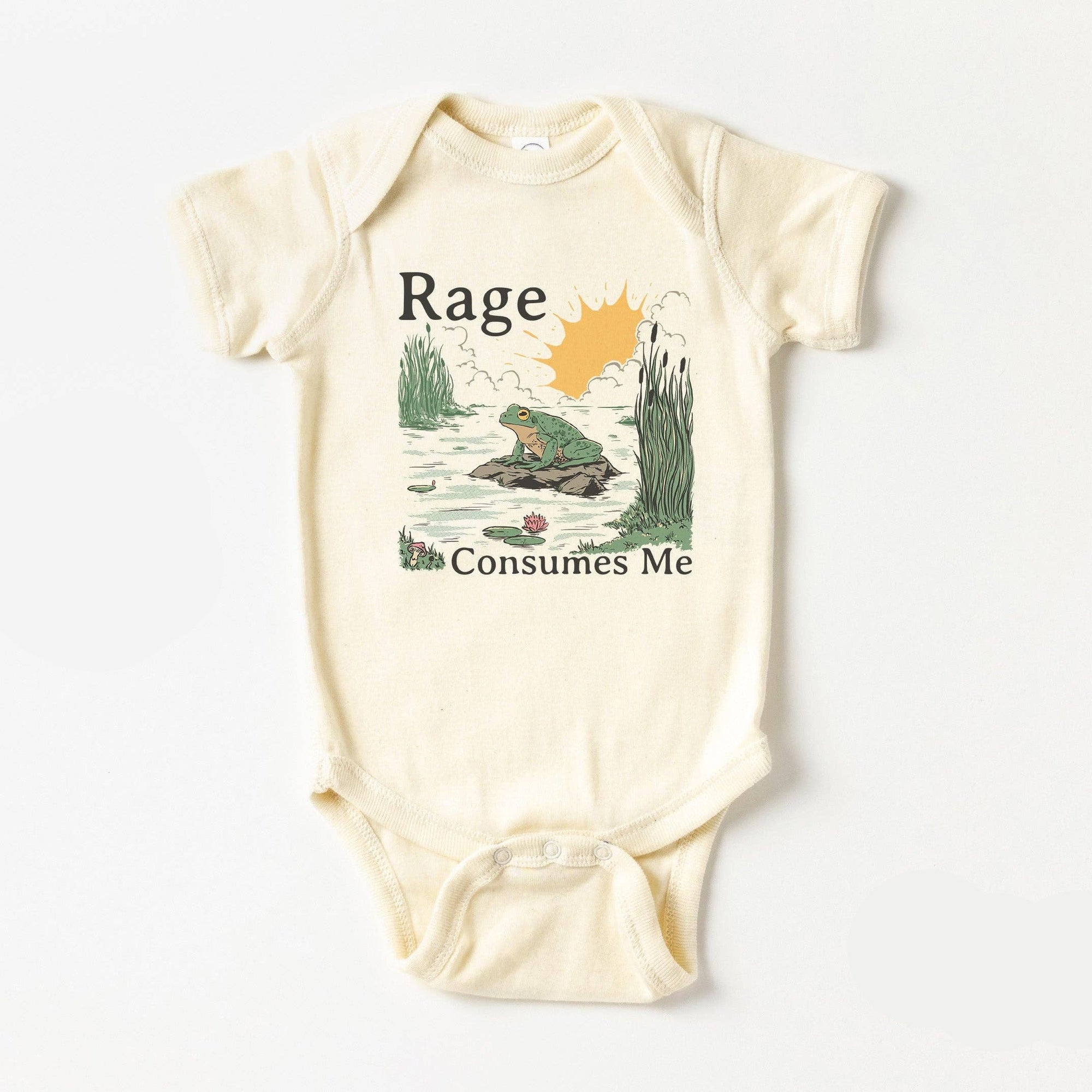 Baby onesie with frog graphic and text 'Rage Consumes Me' on a white background, branded by Blue Giraffe.