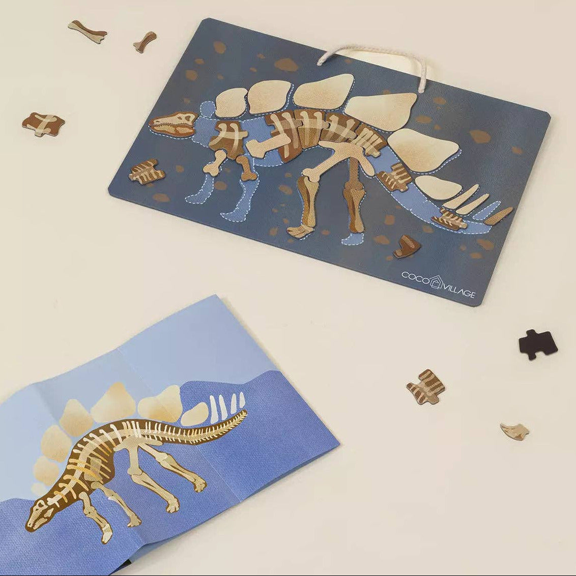 Dinosaur skeleton puzzle with packaging on a light beige background