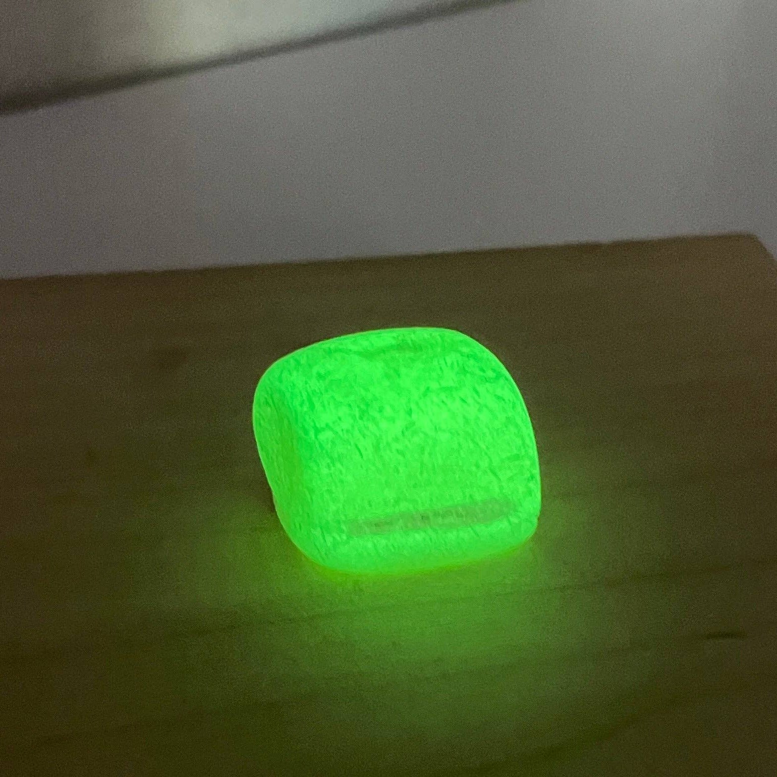Green glowing cube on a wooden surface